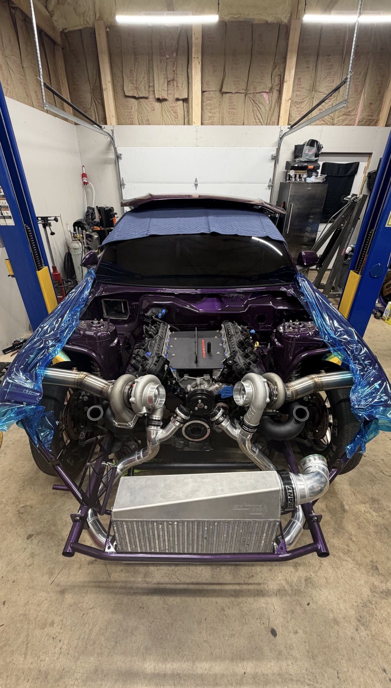 A twin-turbocharged race car under construction on the lift in the Noro Performance workshop